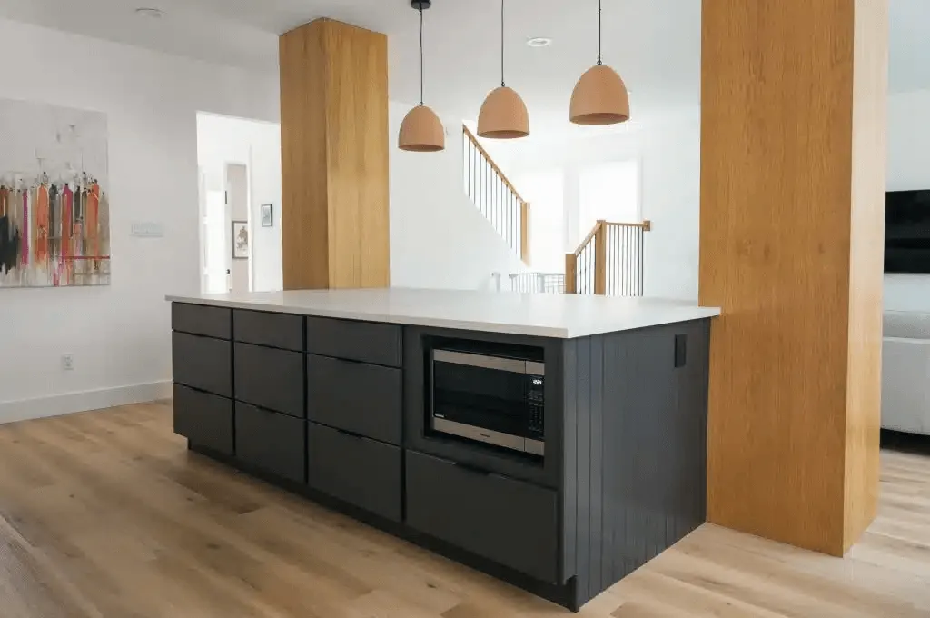 modern kitchen interior with dark cabinets, a white countertop, wooden elements, and pendant lighting CABINET IQ