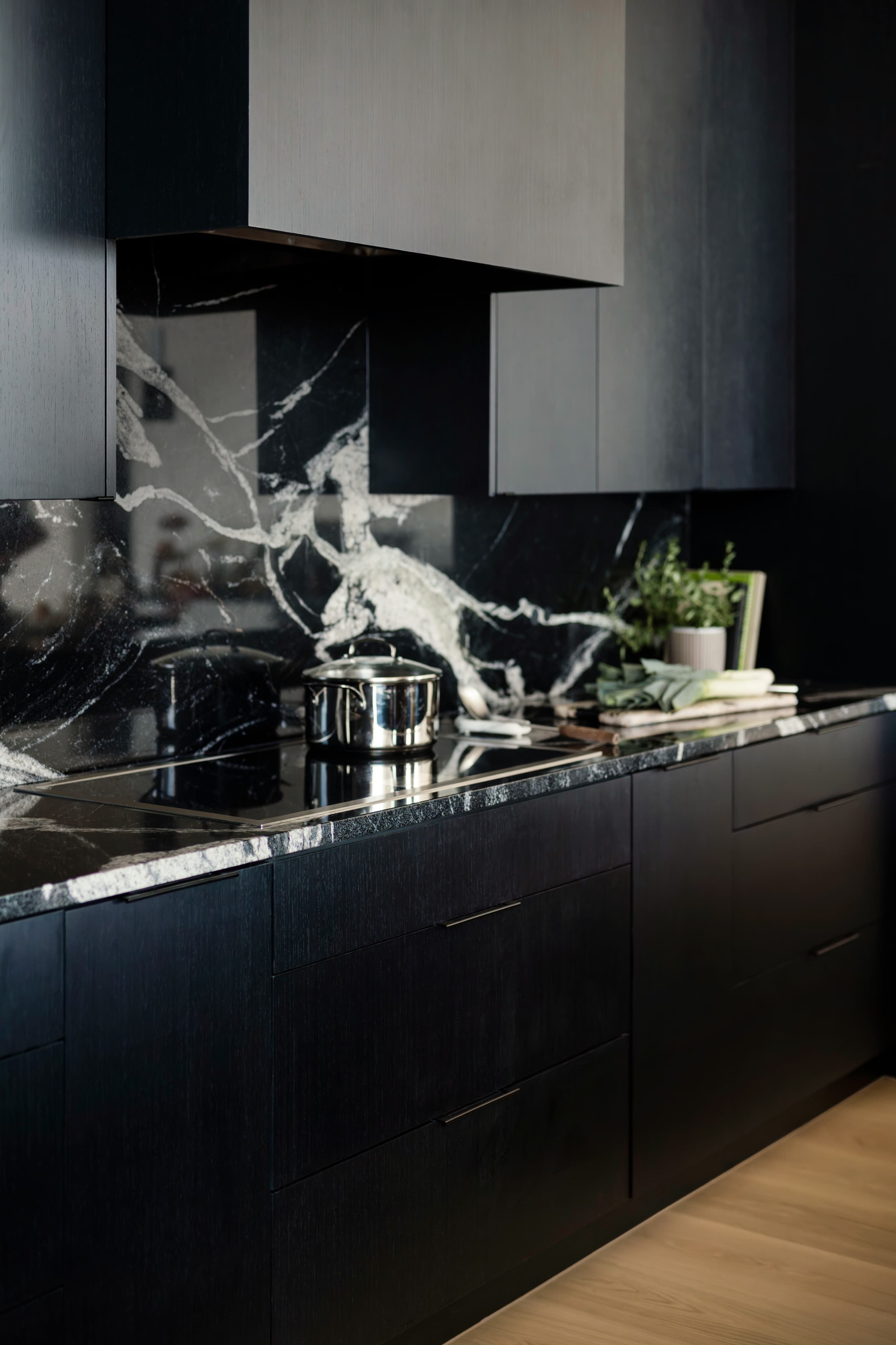 Custom cabinets — black flat-panel cabinetry with marble waterfall island
