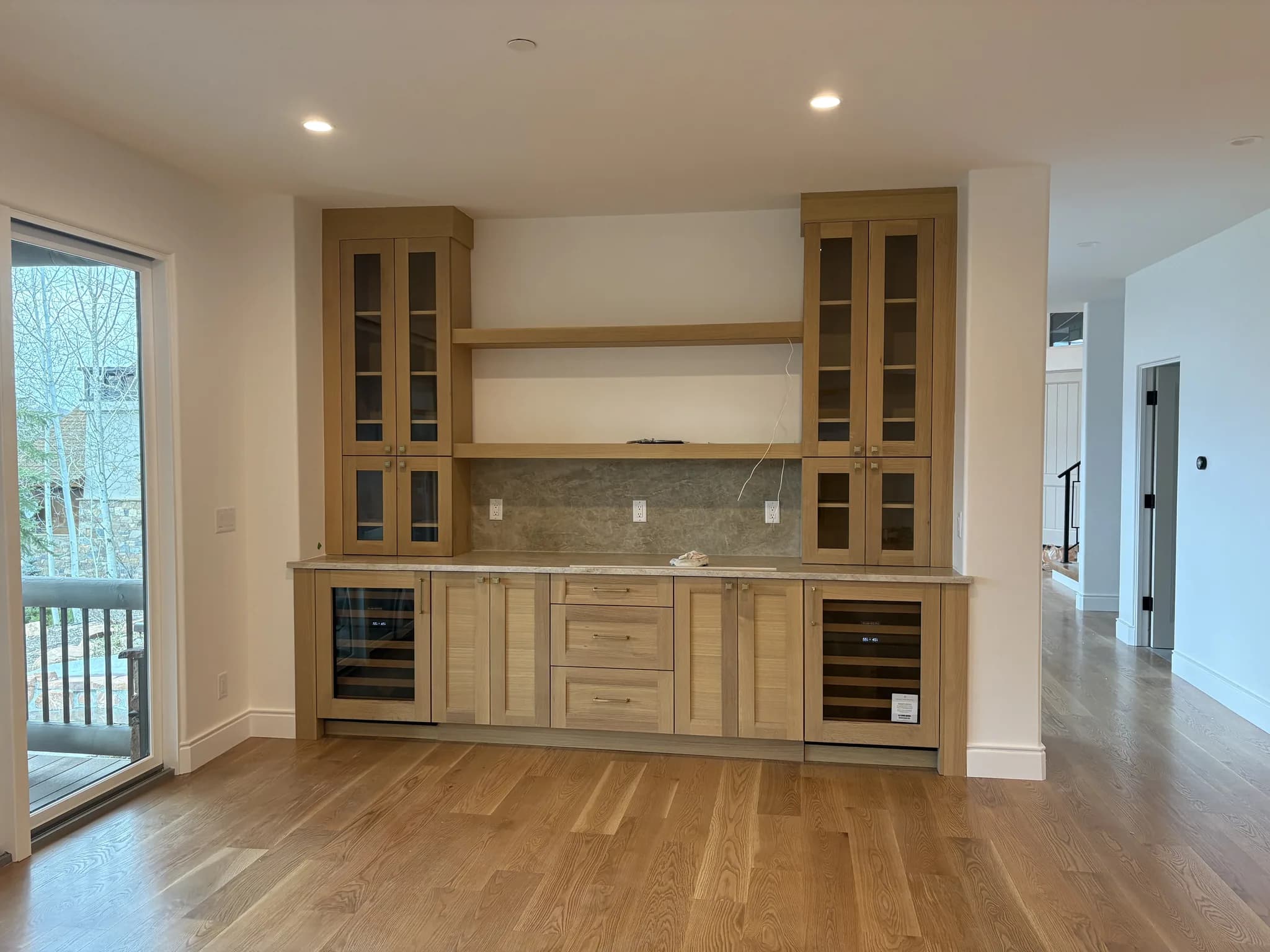 Built-in bar cabinetry with glass-front uppers and beverage refrigerators