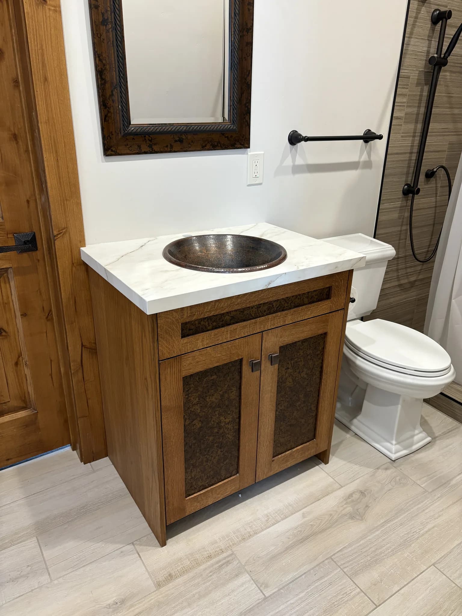 Powder room with a rustic wood vanity and hammered metal basin