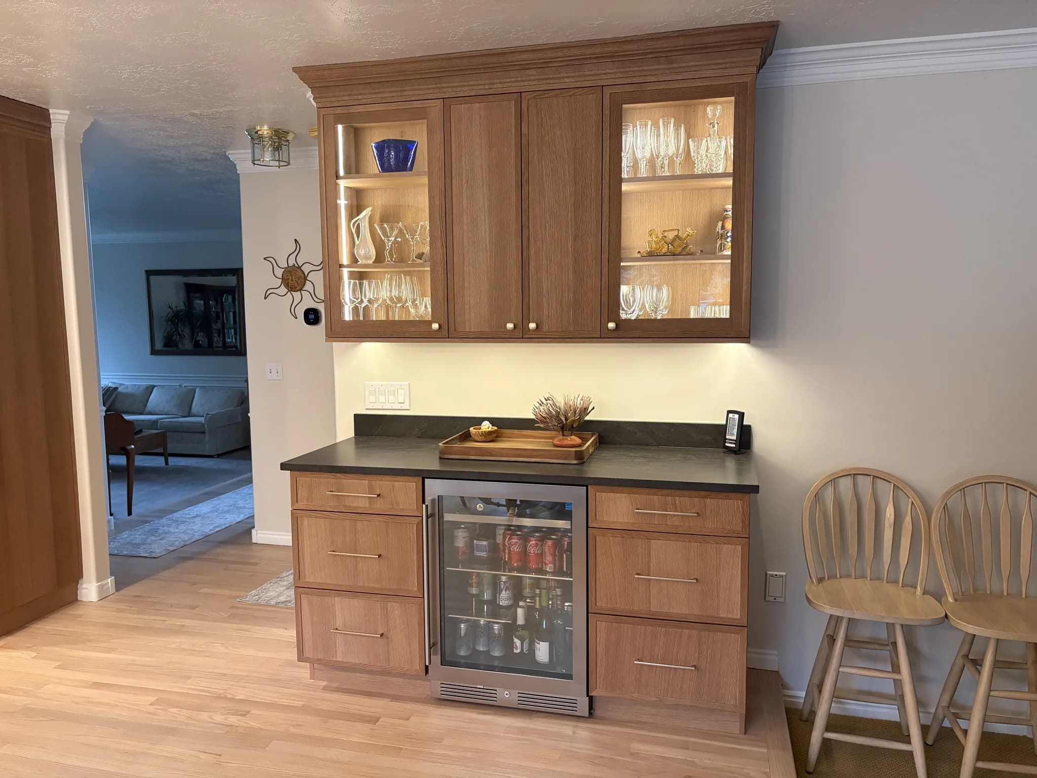 Cherry bar cabinetry with glass-front display doors and a beverage cooler