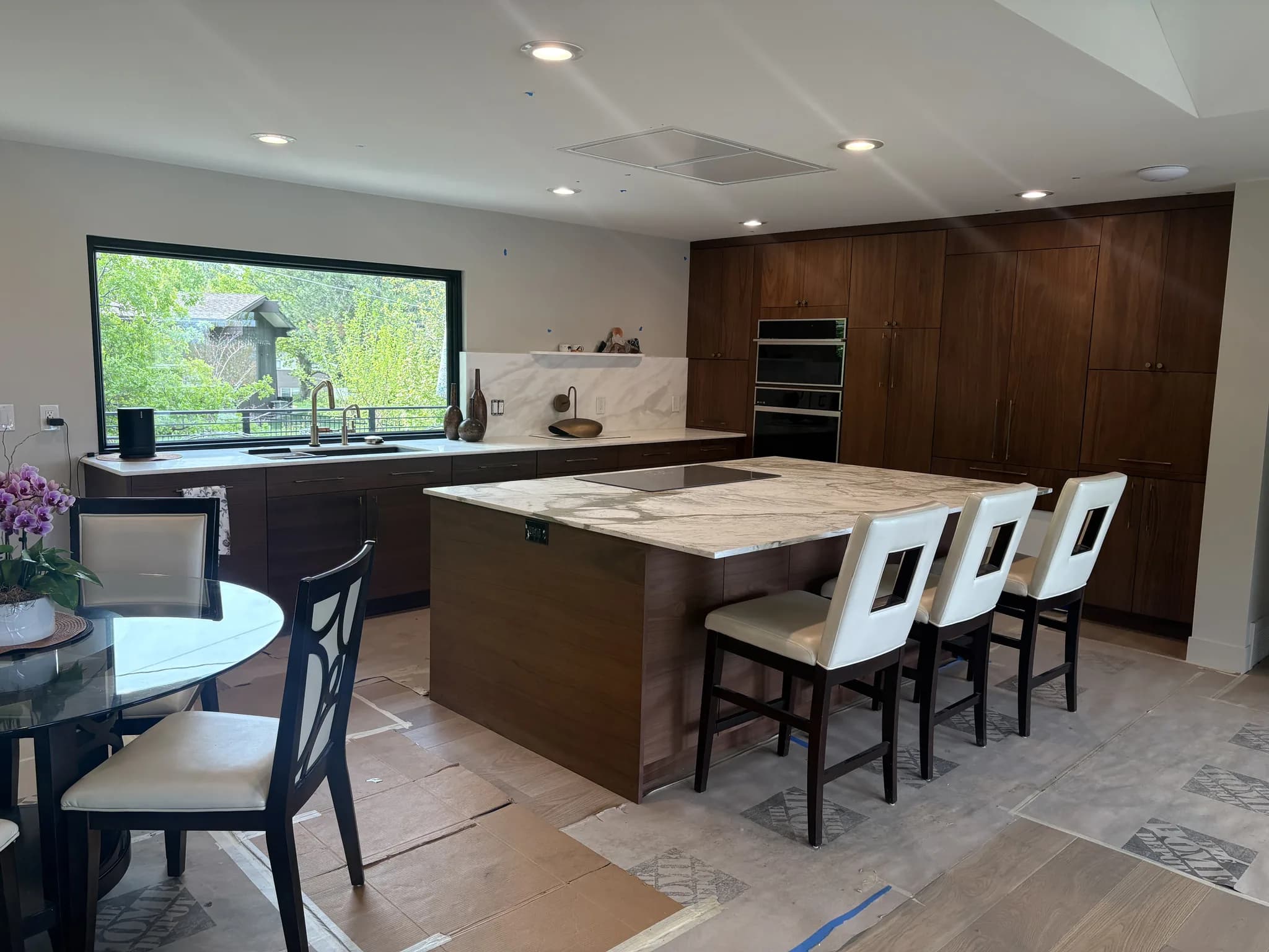 Walnut kitchen with a marble-topped island and upholstered barstools