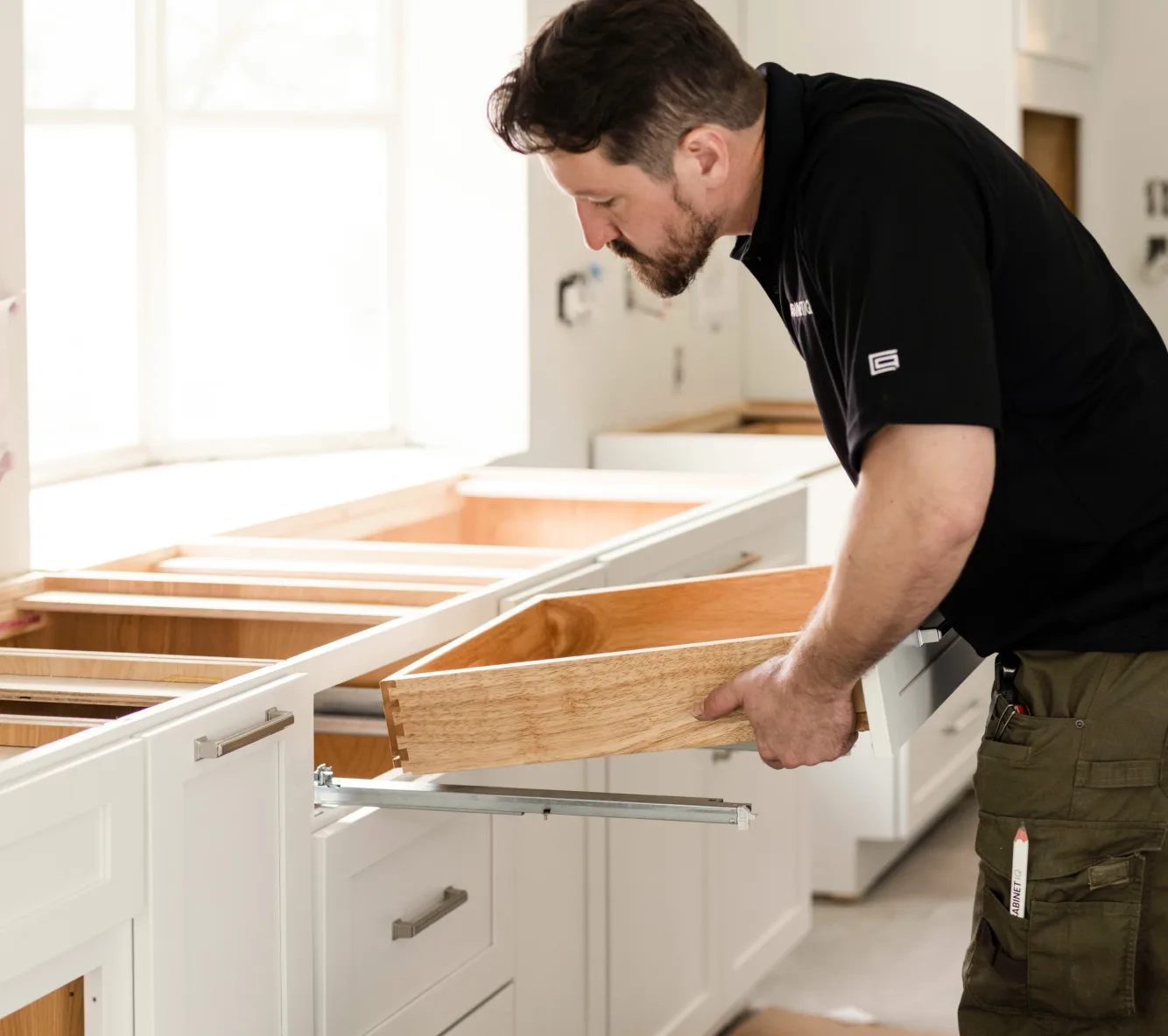 A Cabinet IQ installer fitting a dovetail drawer box into a new cabinet run