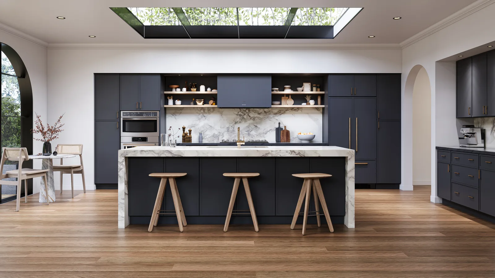 Navy kitchen with a marble-topped island, wood bar stools, open shelving, and a skylight
