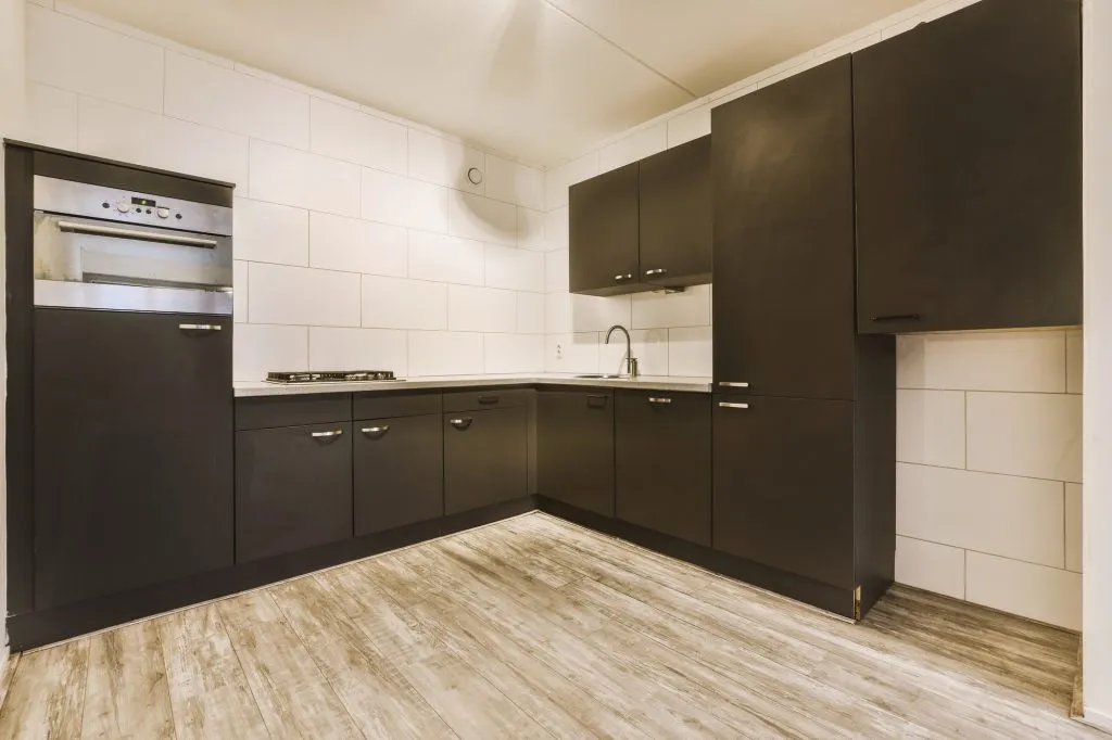 a corner kitchen in black colors in a modern house